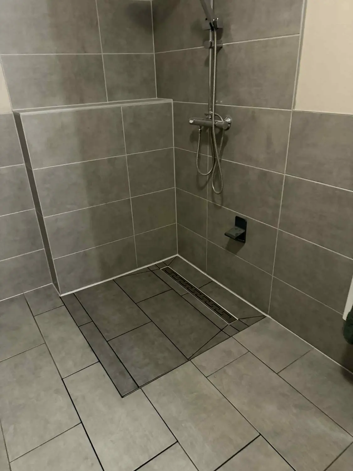Fertige bodengleiche Dusche mit grauen Fliesen