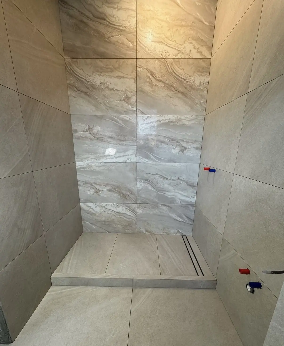 Fliesenarbeiten im Duschbereich mit Marmor-Akzentwand